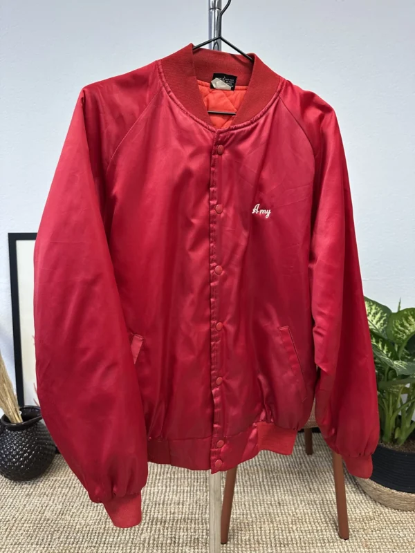 Front view of a vintage red bomber jacket with the word "Amy" embroidered in white on the left chest.