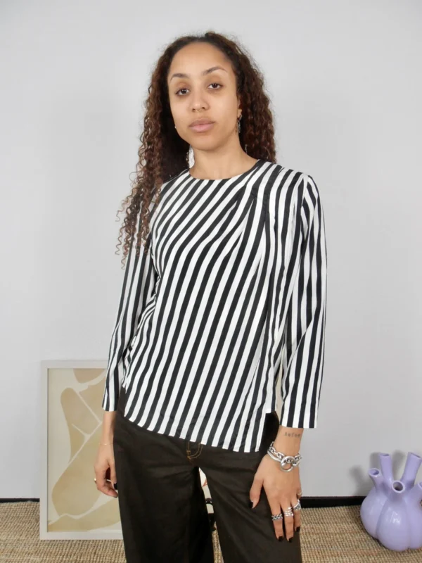 Front view of a vintage black and white striped blouse with side slit detail.